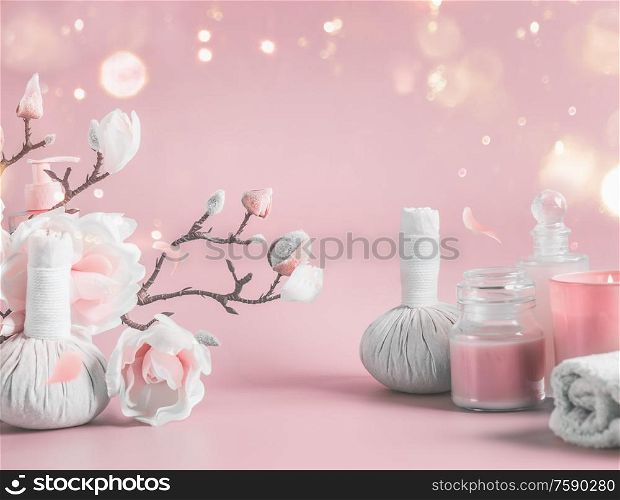 Spa background with body care tools , flowers and cosmetic at pastel pink background with blossom branches and bokeh. Beauty concept