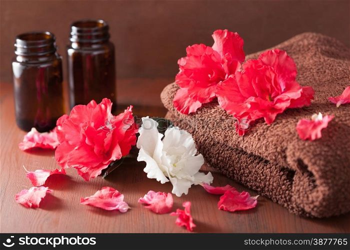 spa bathroom with azalea flowers essential oil on dark rustic background
