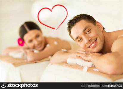 spa, beauty, love and happiness concept - smiling couple lying on massage table in spa salon