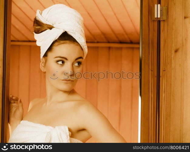 Spa beauty treatment and lifestyle relaxation concept. woman white towel relaxing in wooden sauna room.