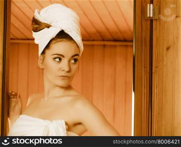 Spa beauty treatment and lifestyle relaxation concept. woman white towel relaxing in wooden sauna room.