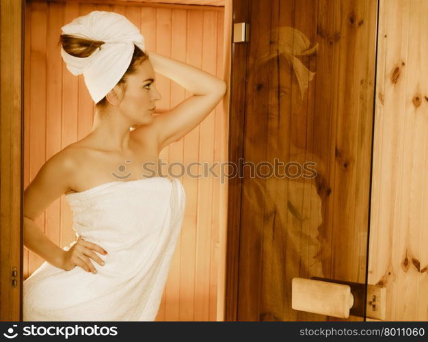 Spa beauty treatment and lifestyle relaxation concept. woman white towel relaxing in wooden sauna room.