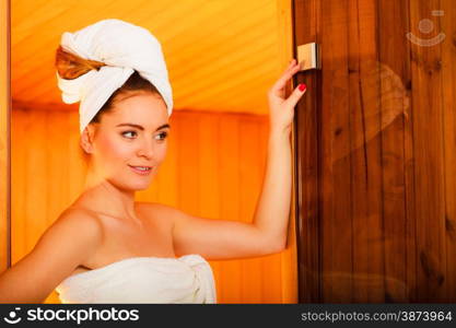 Spa beauty treatment and relaxation concept. Woman white towel relaxing in wooden sauna room.