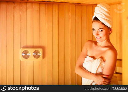 Spa beauty treatment and relaxation concept. Woman white towel relaxing in wooden sauna room.