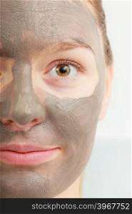 Spa beauty treatment and skin care. Closeup part of female face with clay mud facial mask.