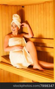 Spa beauty well being and relax concept. Woman in white towel sitting relaxed in wooden sauna