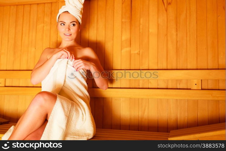 Spa beauty well being and relax concept. Woman white towel sitting relaxed in wooden sauna