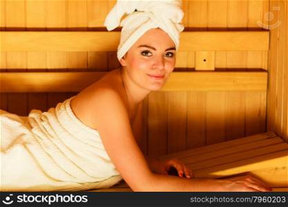 Spa beauty well being and resort concept. Woman in full length white towel lying relaxed in wooden finnish sauna