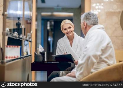 Spa day. A man and a woman in a white robe sitting in a spa center. A man and a woman in a white robe sitting in a spa center