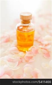 spa, health and beauty concept - closeup of essential oil and rose petals