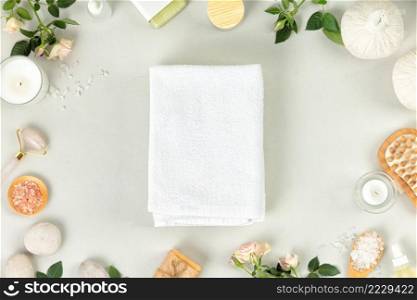 Spa massage Aromatherapy body care background. White towel, natural SPA accessories and flowers on gray concrete table. Beauty and health care concept