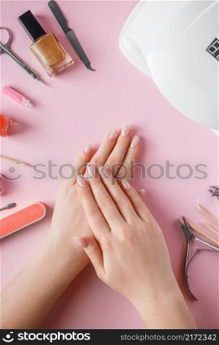Spa procedure for nail care in a beauty salon. Female hands and tools for manicure on a pink background. Bodycare concept.. Spa procedure for nail care in a beauty salon. Female hands and tools for manicure on pink background. Bodycare concept.
