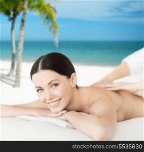 spa, resort and vacation concept - smiling woman in spa salon getting massage
