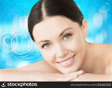 spa, resort and vacation concept - smiling woman in spa salon lying on the massage desk