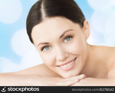 spa, resort and vacation concept - smiling woman in spa salon lying on the massage desk