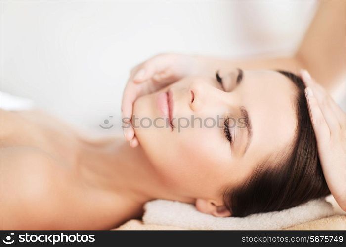 spa, resort, beauty and health concept - beautiful woman in spa salon getting face treatment