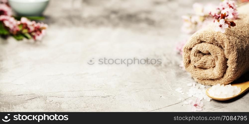 Spa setting. Towel, spring flowers and sea salt on rustic background