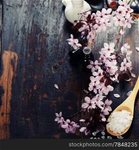 Spa setting with cherry blossoms over wooden background