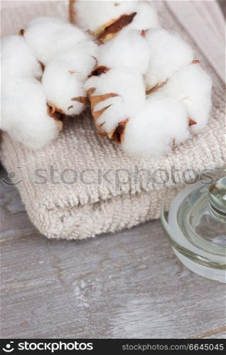 spa setting with cotton buds and towels on gray wooden table. cotton spa