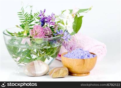 Spa setting with flowers and lilac bath salts
