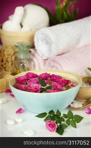 Spa setting with flowers, sea salt, towels and essential oil