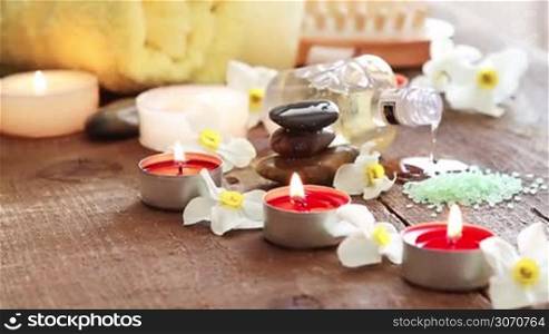 Spa still life of massage oil towel rocks and flowers