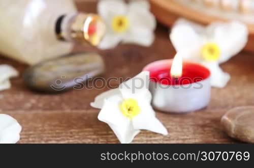 Spa still life of rocks bath salt massage oil and flowers