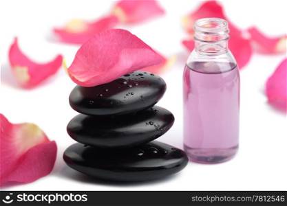 spa stones, essential oil and rose petals isolated
