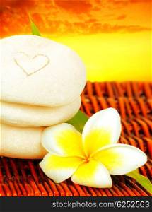 Spa stones in balance &amp; frangipani flower over sunset, concept of vacation, relaxation, meditation &amp; healthy balanced lifestyle