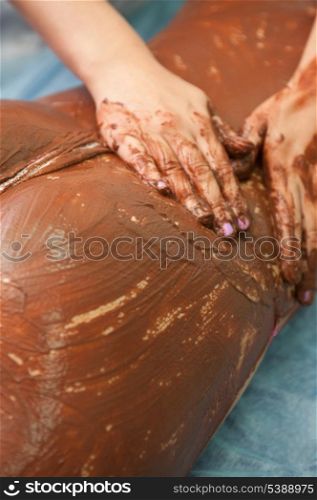 Spa therapy for woman receiving cosmetic chocolate mask