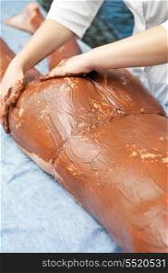 Spa therapy for woman receiving cosmetic chocolate mask