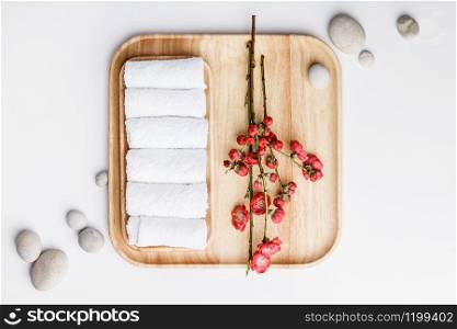 Spa treatment concept, flat lay composition with towels and spring flowers on white background