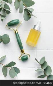 Spa treatment concept. natural spa cosmetics products with eucalyptus oil, massage jade roller, eucalyptus leaf. Massage and spa concept