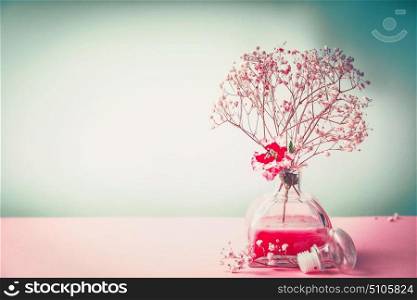 Spa , wellness or natural cosmetic still life with bottle of lotion and flowers on pastel color background, front view, banner, beauty concept