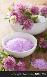 spa with purple herbal salt and clover flowers
