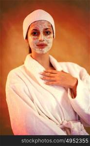 Spa Woman applying Facial Mask Beauty Treatments Close up portrait of beautiful girl with a towel on her head applying facial mask
