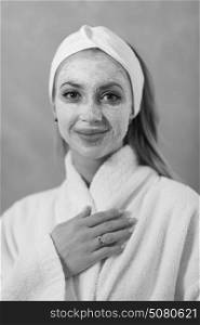 Spa Woman applying Facial Mask Beauty Treatments Close up portrait of beautiful girl with a towel on her head applying facial mask