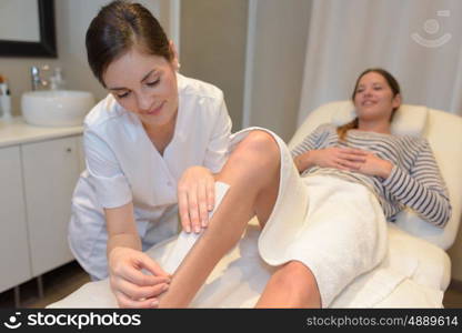 spa woman waxing her leg