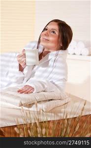 Spa - Young woman at wellness therapy treatment relaxing with cup of tea