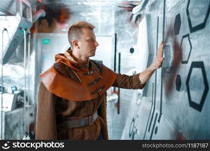 Space scientist holds wires at the control panel in spacecraft with foil walls. Fantasy spaceship for interstellar travel, future science and technology, universe discovery. Space scientist holds wires at the control panel
