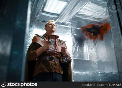 Space traveler looks out of the teleport with foil walls. Fantasy spaceship for interstellar travel, future science and technology, futuristic shuttle. Space traveler looks out of the teleport, shuttle