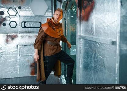 Space traveler looks out of the teleport with foil walls. Fantasy spaceship for interstellar travel, future science and technology. Space traveler looks out of the teleport, shuttle