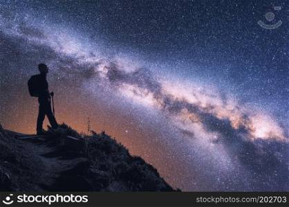 Space with Milky Way and silhouette of a woman with backpack at night in Nepal. Young girl on the mountain peak and starry sky. Sky with stars. Trekking. Landscape with bright milky way and traveler