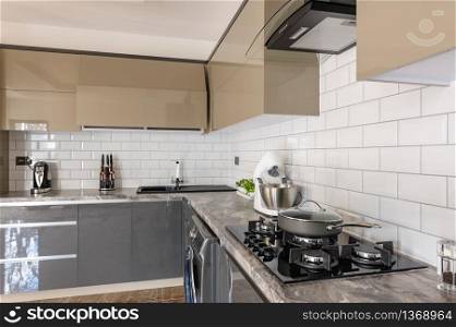 Spacious luxury well designed modern grey, beige and white kitchen, closeup to working surface. Closeup of luxury modern white, beige and grey kitchen interior
