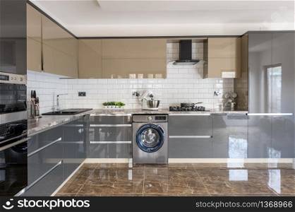 Spacious luxury well designed modern grey, beige and white kitchen with marble tiles floor. Luxury modern white, beige and grey kitchen interior