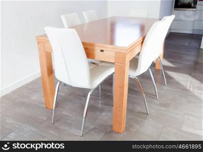 Spacious room with wooden table and white chairs