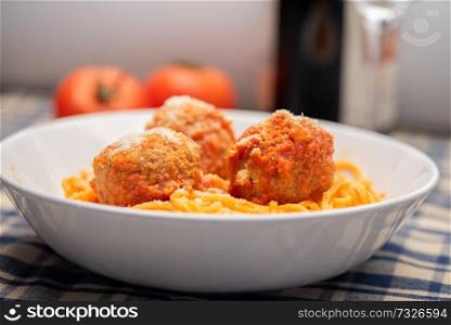 spagetthy and meatballs with tomato sauce and grated cheese