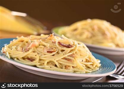 Spaghetti alla Carbonara made with bacon, eggs, cheese and black pepper (Selective Focus, Focus one third into the meal)