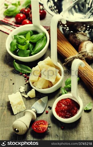 Spaghetti and italian ingredients on wooden table