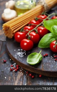 Spaghetti and tomatoes with herbs on an old and vintage wooden table